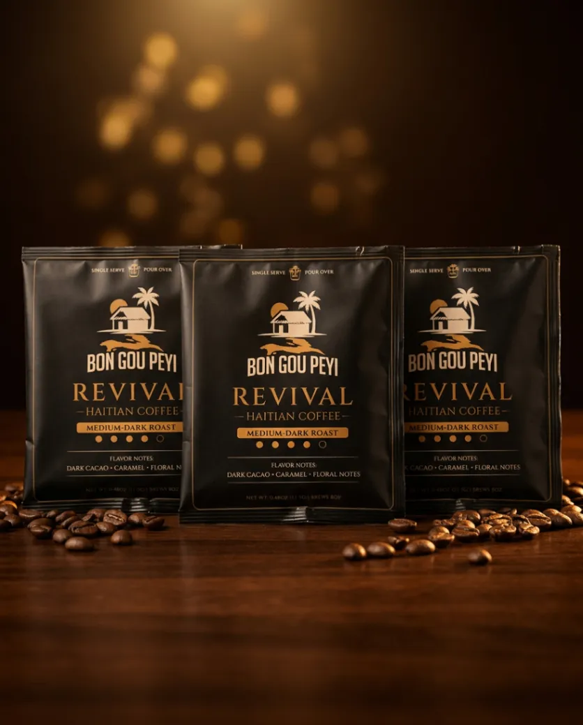 Three REVIVAL Haitian Coffee single-serve pouches on a dark wooden table with warm cinematic light